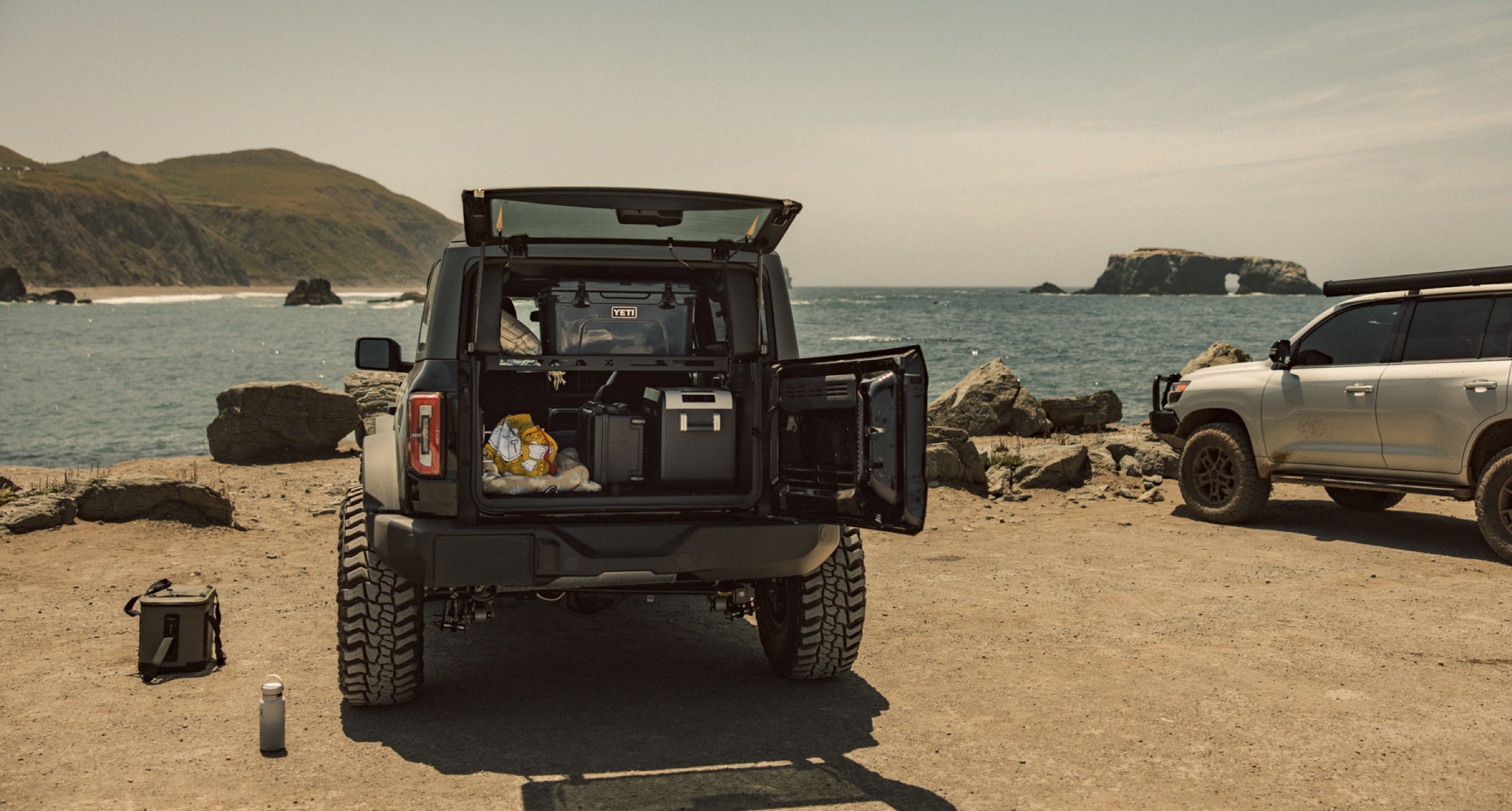 Platform A Bronco loaded with a Yeti cooler and fridge at the coast