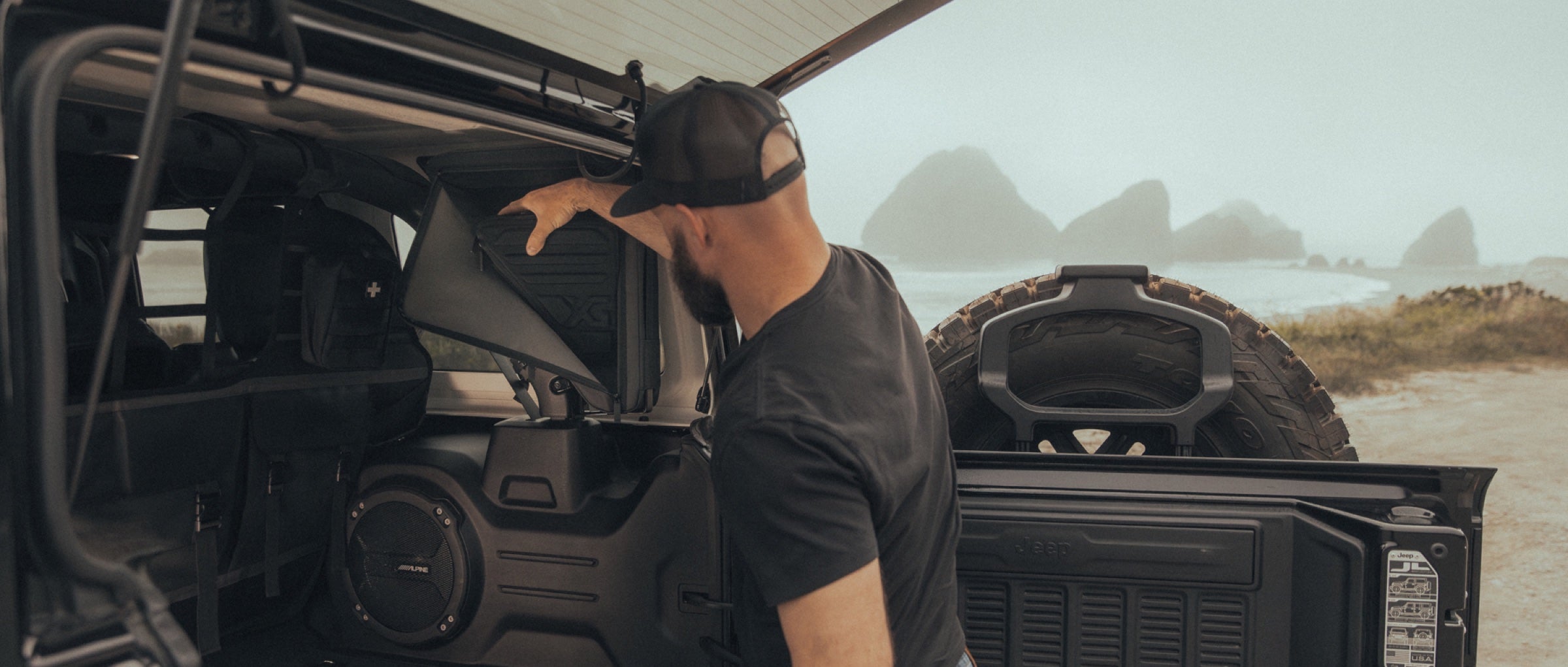 Opening the Gama Adventure bag on the Jeep roll bar at the coast